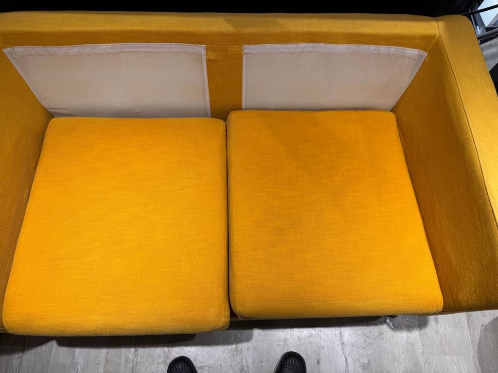Nettoyage de canapé pour particuliers sur canapé en tissu jaune après traitement des assises avec rendu uniforme