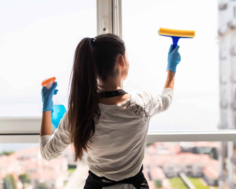 Nettoyage de vitres pour particuliers à domicile avec raclette pour un résultat sans traces